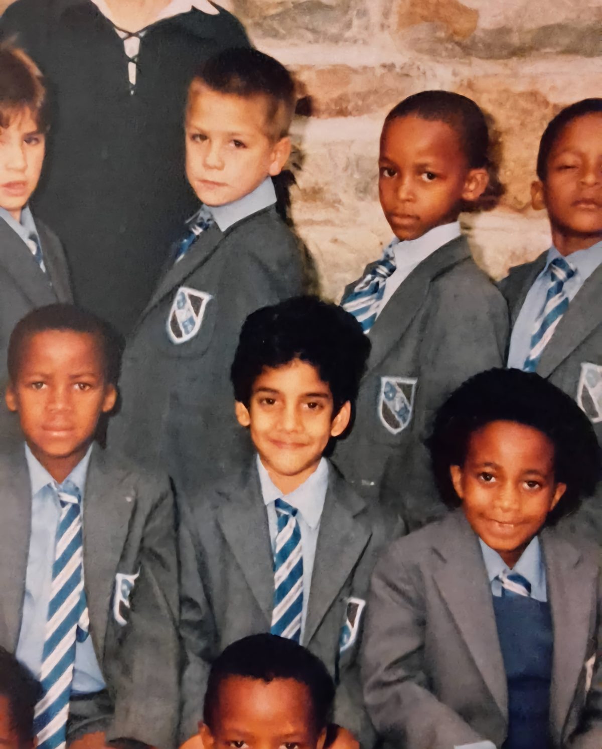 A school class photograph from Norwyn K's childhood, pupils in grey blazers and striped ties.